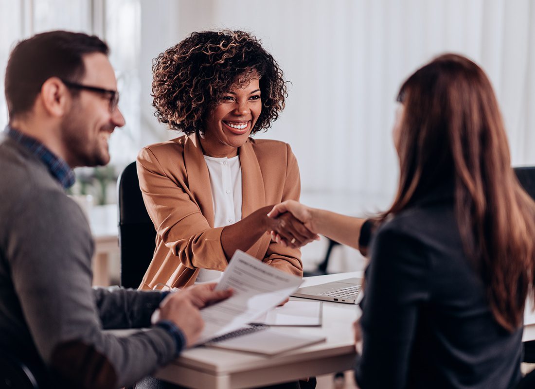 About Our Agency - Friendly Agents Meet With a Client and Shake Hands