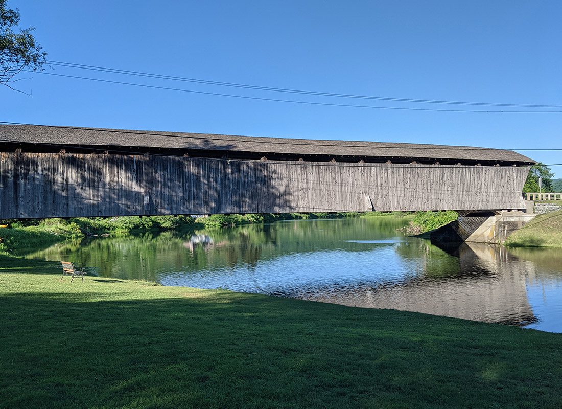 Downsville, NY - Covered Bridge Crossing a River on a Sunny Day